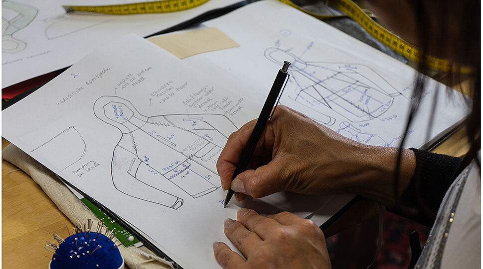 Freyzein - Designer beim Zeichnen eines Kleidungsentwurfs