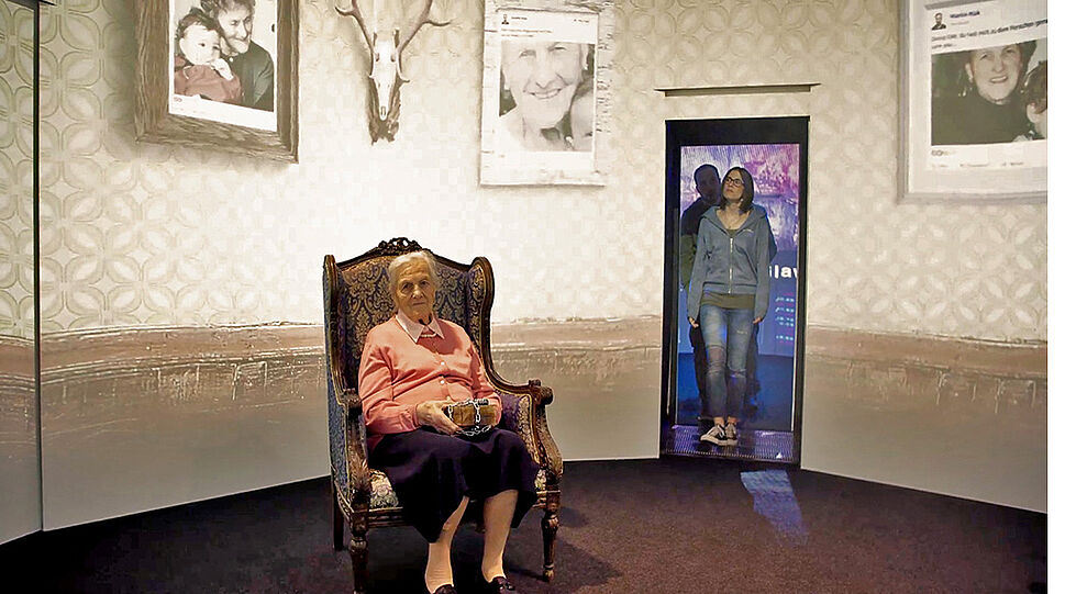 1001 Rooms - Betreten eines digital bespielten Raum, alte Frau auf Sessel sitzend