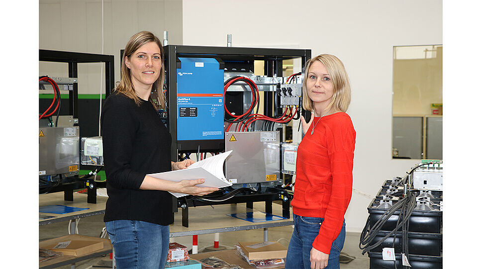 Anita Eggl, Sales, und Carina Hemetsberger, Betriebsleitung, vor einem GREENROCK Salzwasser-Stromspeicher