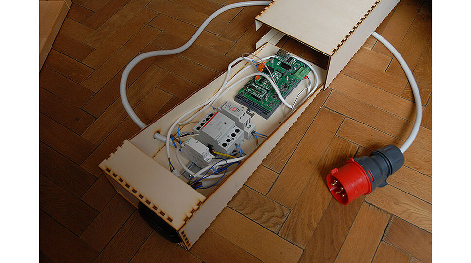 Etonomy Prototyp einer Ladestation - offene Holzkiste mit Elektronik drinnen
