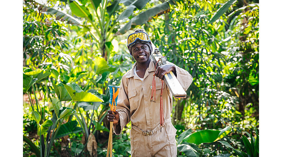 Mann in Uganda mit Schi und Bambusstöcken