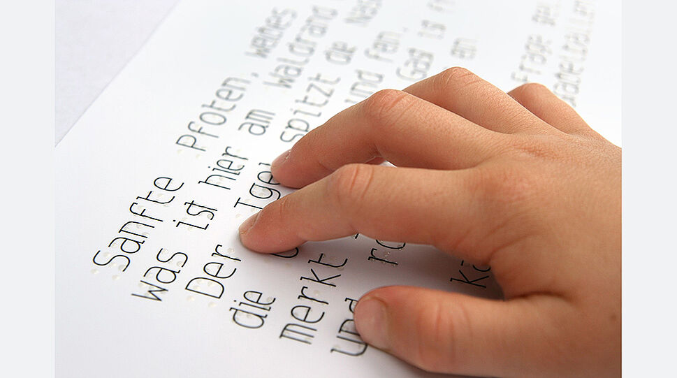 Kinderhand tastet die Blindenschrift im LUCKY DOTS-Kinderbuch