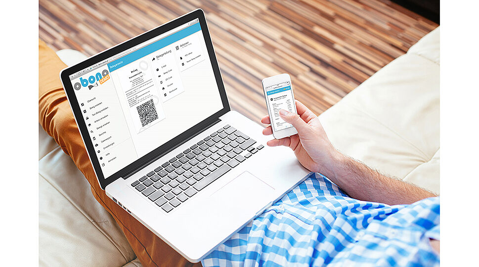 Mann mit Laptop am Schoß und Smartphone in der Hand - beide Geräte zeigen das obono-interface